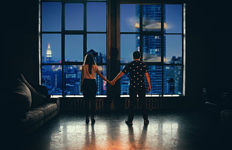 man and woman holding hands in front of glass window thumbnail