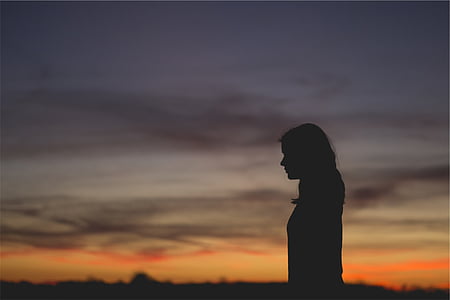 silhouette of woman standing during sunset thumbnail