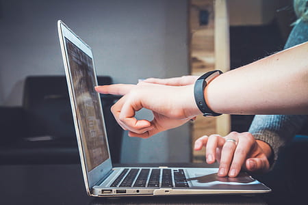 person wearing black Fitbit alta and pointing on laptop monitor thumbnail