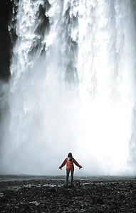woman standing in front of waterfalls at daytime thumbnail