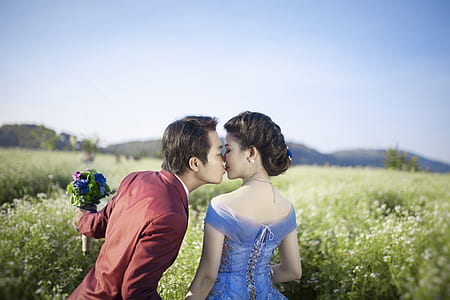 man holding flowers while kissing woman during daytime thumbnail