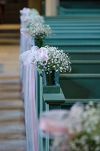 white baby's breath flowers in gray pot on top gray wooden pew thumbnail