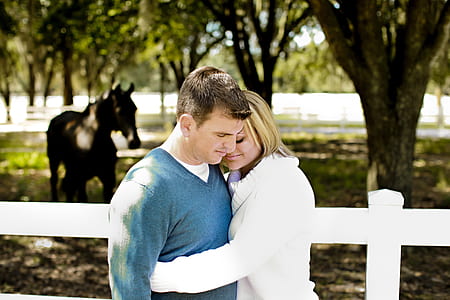 woman wearing white sweater hugging man wearing blue sweater thumbnail