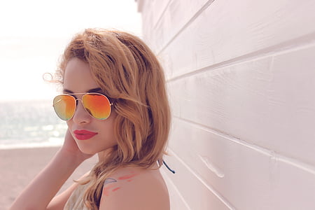 woman in gold-colored framed aviator-style sunglasses thumbnail