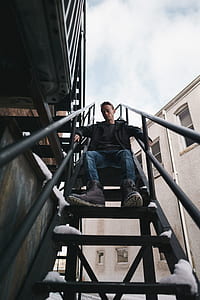 man sitting on staircase at daytime thumbnail