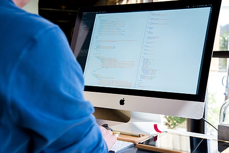 person wearing blue shirt in front of silver iMac thumbnail
