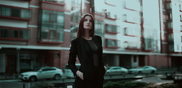 woman wearing black long-sleeved dress standing near building at daytime thumbnail