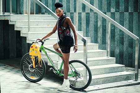 Woman Wearing Black Dress Riding Bicycle Near Stairs thumbnail