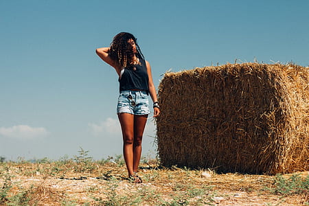 woman wearing black top standing near brown hays under blue sky during daytime thumbnail