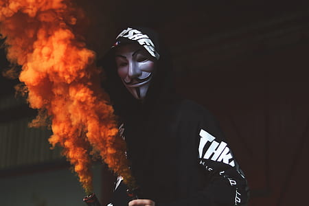 person wearing Guy Fawkes mask opening pump with orange smoke thumbnail