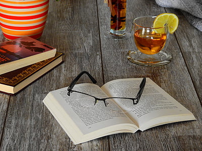 eyeglasses on book beside glass cup thumbnail