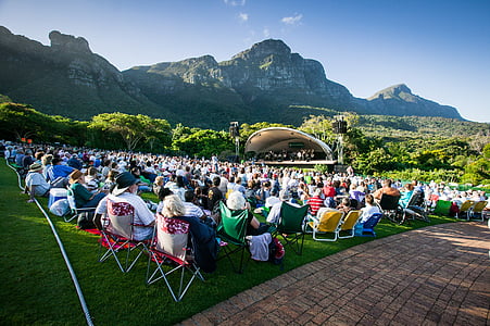 group of people sitting near beige stage across land formation photo during daytime thumbnail