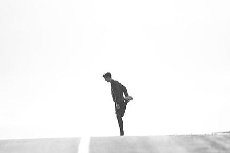 man in black suit doing leg stretching in grayscale photography thumbnail