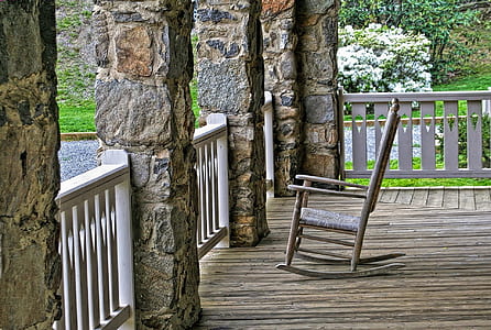 brown wooden framed rocking chair near white wooden fence thumbnail