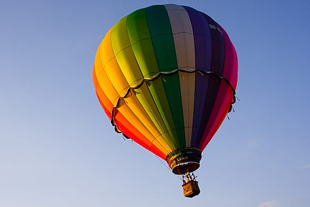 blue, yellow, orange, and red hot-air balloon in flight thumbnail