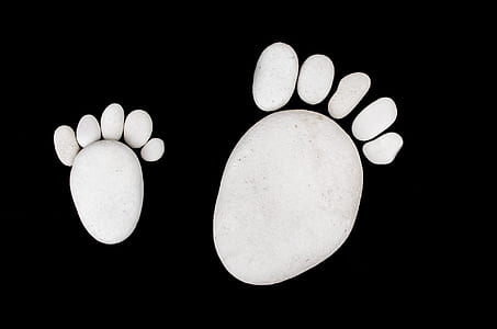 two white foot prints on black background thumbnail