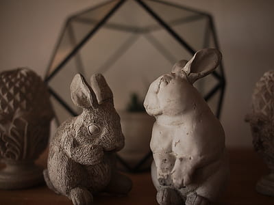 two brown and white rabbit figurines on table thumbnail