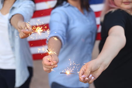 three person holds lighted sparkler firecrackers thumbnail