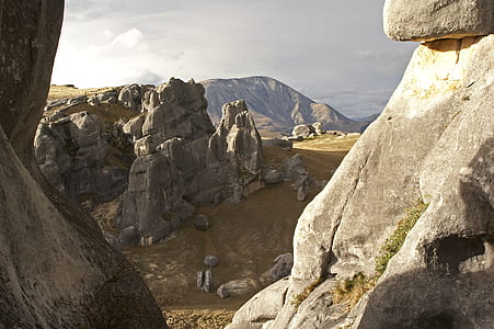 rock formation in the middle of grass field thumbnail