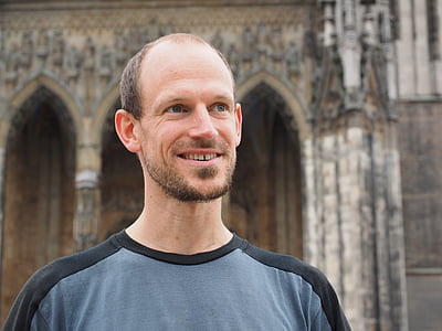 close-up photography of smiling man wearing black and gray shirt thumbnail
