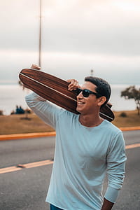 man holding brown skateboard thumbnail