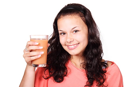 woman holding clear drinking glass with pink liquid thumbnail
