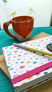 orange and white fox mug near notebook thumbnail