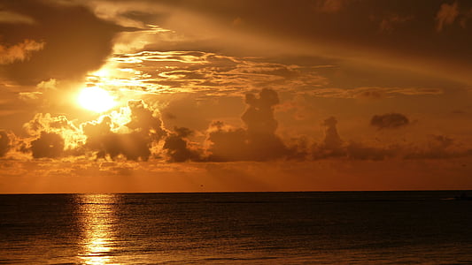 silhouette photography of body of water during golden hour thumbnail