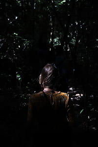 woman wearing beige and multicolored floral crew-neck top between tall trees during daytime thumbnail
