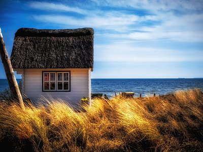 photography of white house by the beach under blue sky thumbnail
