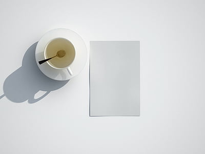 white cup on top of saucer near paper thumbnail