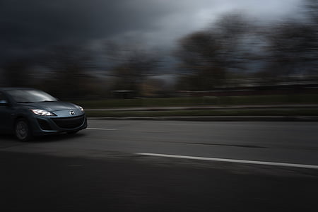 selective focus photography of silver Mazda 3 crossing road at daytime thumbnail