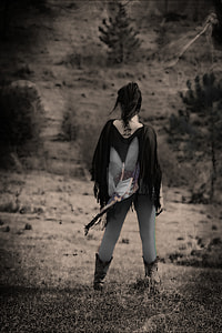 woman wearing cowboy boots standing at the field during day thumbnail