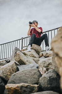 man holding camera while taking photo thumbnail