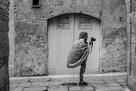 gray statue beside white wooden door thumbnail