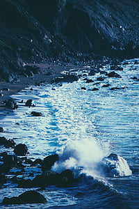 seafoam on shore with rock at daytime thumbnail