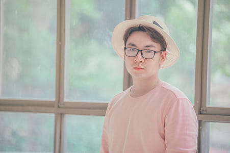 Man Wearing Pink Top Standing Near Glass Panel thumbnail