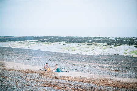 man and woman sitting on beach thumbnail