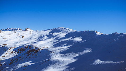 aerial photography of snow covered mountain under blue sky at daytime thumbnail
