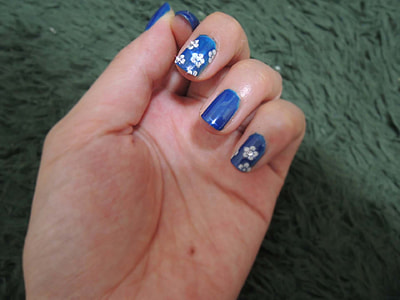 person's hand with blue manicure thumbnail