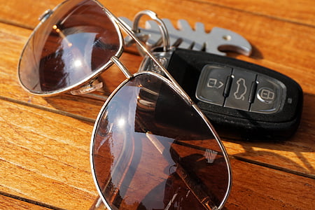 brown aviator sunglasses and key fob on table thumbnail