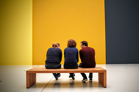 three people sitting on wooden bench thumbnail