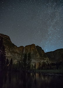 landscape photography of rocky mountain under starry night thumbnail