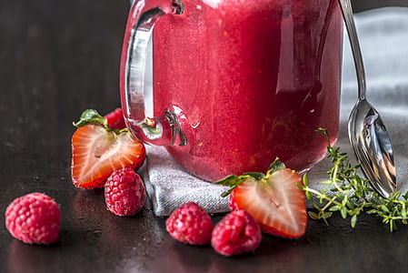 sliced strawberries and raspberries beside clear glass pitcher thumbnail