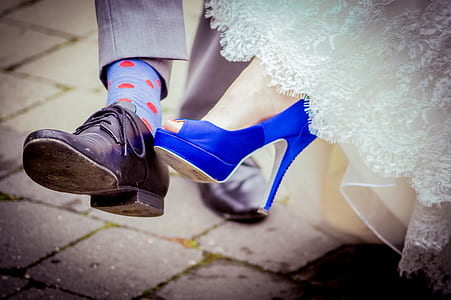 person wearing black dress shoe and blue peep-toe heeled sandal thumbnail
