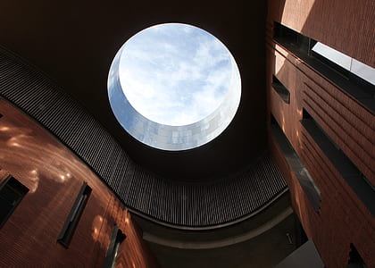interior of brown and black building with hole in ceiling low-angle photography thumbnail