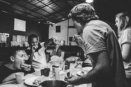 family of four eating at the restaurant in grayscale photo thumbnail