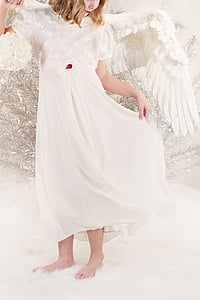 girl wearing white dress and wings standing on white rug thumbnail
