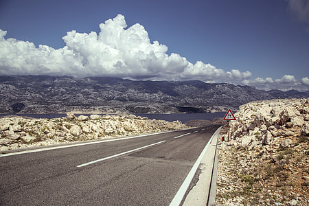 aerial view of asphalt road under cloudy sky thumbnail
