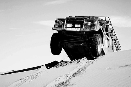 grayscale photography of vehicle on desert during daytime thumbnail